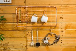 簡單的黃銅編織而成的壁架，掛著白瓷馬克杯與棕刷，簡簡單單的樣貌不就是現代人追求的返璞歸真？