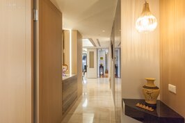 由客廳走入連結臥室與廚房餐廳的走廊，一眼就可以看到全貌。設計師巧妙的利用嵌入式LED燈具與吊燈，營造出溫暖又有質感的居家風情。