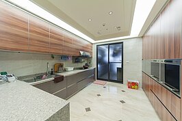 半開放式空間的廚房擁有面積十分大的料理台。屋主表示若不是面積還不夠大，要不然很想裝個中島作為料理輕食與簡單會餐時使用。