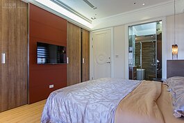 客廳所呈現的東西方元素較為濃厚，在主臥室內則是並未這麼著重，可以看出西方藝術線條的就是天花板的四邊勾邊。不過更為搶眼的就是掛著電視的赭紅色衣櫃牆面。若是預算夠，這個牆面可用人造皮包覆，將會更有質感。