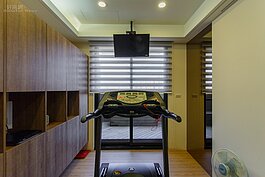 運動間不大，僅能容入一台跑步機。令人詫異的則是左側的櫃子是系統櫃，而非一般人認為現場木作所做的櫃子。設計師強調，系統櫃採機械方式精準生產，在價格上比較實惠且款式多。