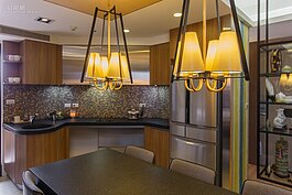 餐桌燈具部分不選用容易積灰塵又需花時叫清理的水晶吊燈，而是改採溫潤紙質的燈罩型款式。