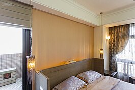 為了結構安全，難以避免在屋內有著梁橫過，在主臥房也不例外。一般做法就是會利用木作將天花板降低以便將梁包覆起來。設計師則是用更為簡單的做法就讓男女主人在睡眠時可以避開主梁。做法不難，床頭往前移動些許就好，多出來的空間則是利用人造石與木板進行填補。