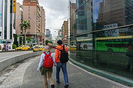 不明究理的外國遊客由圓環邊走過，卻不知身邊這個建物即將消失。