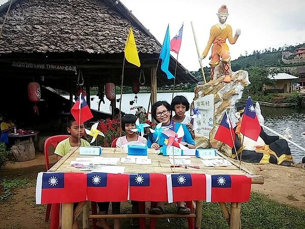 7. 吳淑丸到泰北當志工,孤軍的華人遺孫開心與國旗合照。