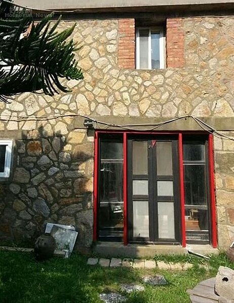2. 外觀為石頭堆砌的水泥小洋房。