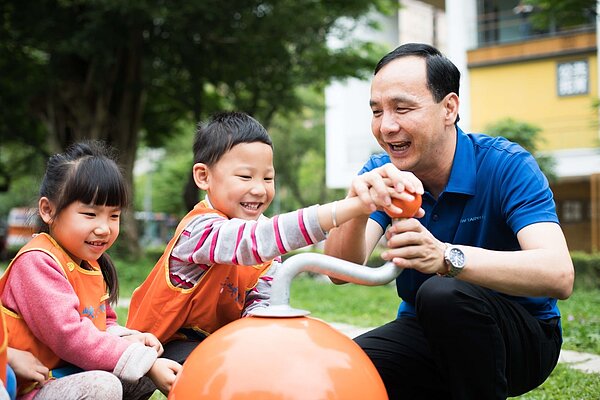 新北市長朱立倫與小朋友一起玩遊戲並宣示新北將要推共融式遊具。（圖／新北市城鄉局提供）