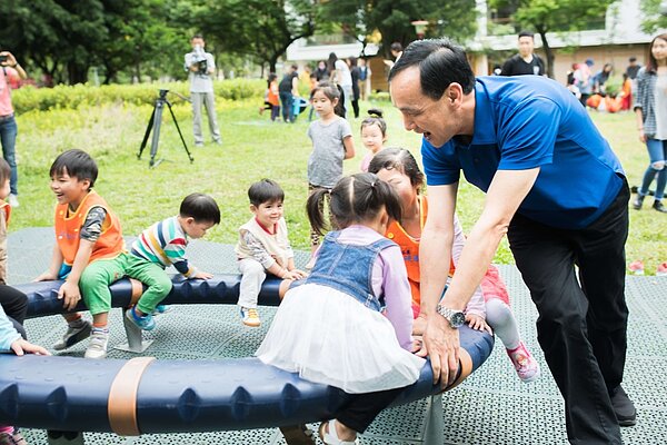 新北市長朱立倫與小朋友一起玩遊戲並宣示新北將要推共融式遊具。(圖/新北市城鄉局提供)