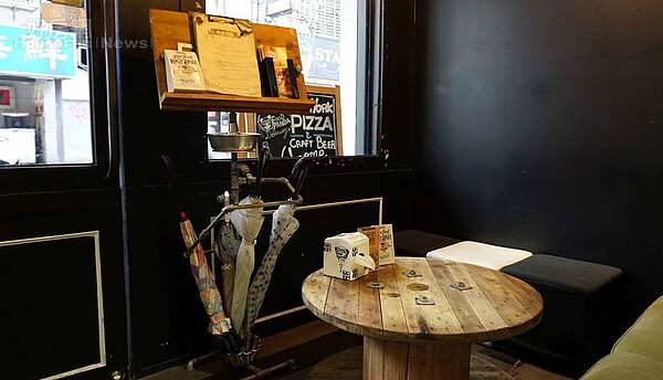 4.玄關處為舒適的沙發區,門口擺放用水管打造的傘架,同時還兼具Menu單與煙灰缸功能,是萬子豪請友人客製化設計的。