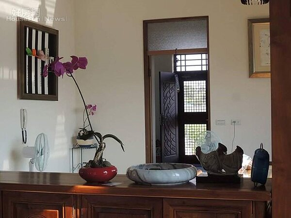 7. 室內擺設著石雕、蘭花與書畫作品。