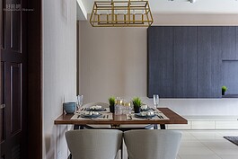 簡單的餐桌與簡單的吊燈，搭配背景客廳深色吊櫃與同色系壁紙，反而可營造出輕文青風的感覺。