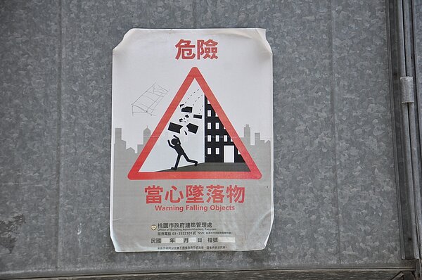 桃園市中壢區中央西路一段的一棟老舊商場大樓,後側陽台斑駁鏽蝕,市府建管處張貼警告標示。 記者張裕珍/攝影