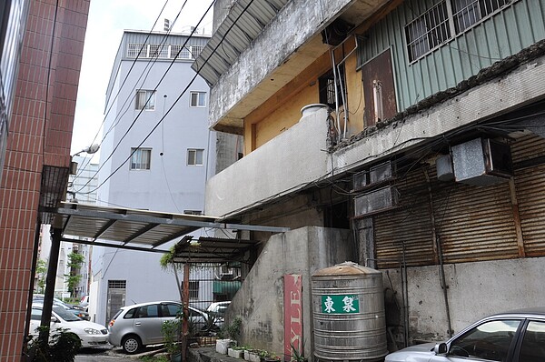 桃園市中壢區中央西路一段的一棟老舊商場大樓,後側陽台不時掉落水泥塊,後方住戶搭建鐵皮自救。記者張裕珍/攝影 張裕珍