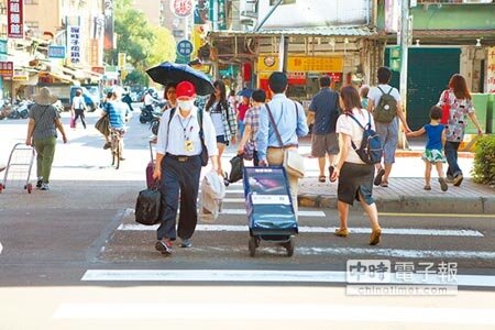 拉行李或推嬰兒車民眾過馬路,走斑馬線到一半遇到分隔島,被迫往馬路中央與車爭道,相當危險。(張立勳攝)