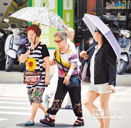 據中央氣象局資料顯示，26日各地高溫平均在攝氏32至35度左右，大台北和台東地區尤其炎熱，圖為民眾撐傘外出防曬。（顏謙隆攝）