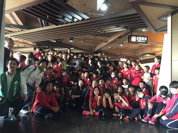 有巢氏房屋志工與博屋瑪國小學童在電影戲院外大合照。(圖/有巢氏房屋)