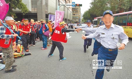 台灣警消聯盟發起軍公教「遍地開花」抗議遊行，大量警方在各重要機關警戒，員警移防時和陳情民眾擊掌加油更比出大拇指讚。（陳君瑋攝）
