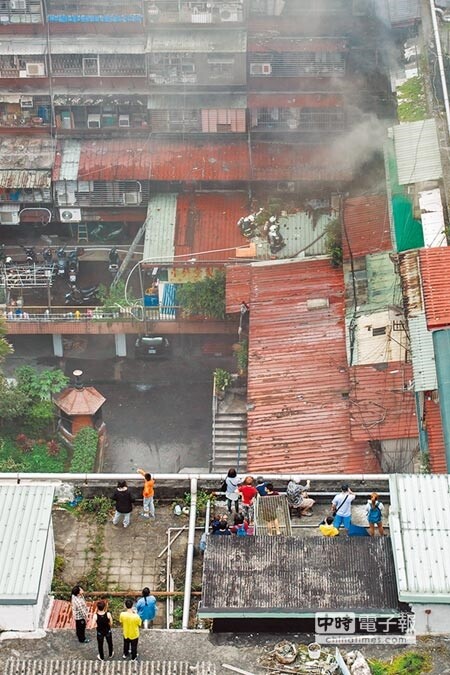 北市萬華區中華路2段一處舊式集合住宅7日清晨發生大火，警消緊急撤離200多名住戶，花了1個半小時，才將火勢撲滅，當地住戶都被嚇得緊急逃生。（郭吉銓攝）