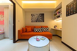 將角度回到客廳。客廳一樣可使用的空間並不大，不過設計師還是硬擠出了一區作為閱讀、加班工作或是擺放電腦上網等多用途開放式小書房。因應居住在此的人口簡單，僅擺放三個座位款式沙發。
照明部份採用間接照明以柔和整體氛圍。