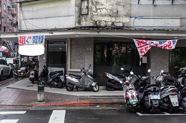 應是黃金地點的三角窗店面，卻大門深鎖，不只裡頭一片黑漆漆，店門口也成了機車停車場。（好房網News記者張聖奕／攝）