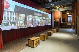 現場透過大型無縫投影方式，將當年茶商的一天以動靜畫交織的方式呈現出來，十分的有看頭。不過在這個位置不僅只是看投影畫面而已，記得抬頭看一下天花板，當年的建築設計令人讚嘆，原來水泥與木頭可以如此的巧妙運用。