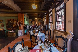 上到二樓後，印入眼簾的是公共電視「紫色大稻埕」劇中使用的道具正在進行展示。紫色大稻埕一劇所描述的是由演員施易男所扮演的大稻埕茶行少爺的故事。也因為劇中主角背景設定為大稻埕茶行，因此新芳春居就成為該劇的拍攝景點之一。