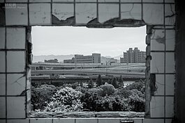 破敗的水泥窗框望出去，交織的高架橋車流行色匆匆，對照寶藏巖這裡的景色，彷彿是另外一個世界。