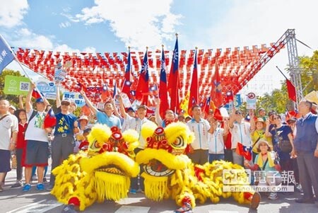 新竹縣政府在光明一路布置旗海隧道,邀民眾一同踩街,體驗國慶復古風情。(莊旻靜攝)