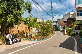 「身為一個汽車維修員，身上有一隻板手是很正常的！」，所以在坑口村的竹林下看到大貓熊也是很正常的！
後面的土磚厝已經在都會中消失了很久很久了。
