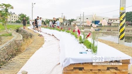 在稻田間農路中的五感餐宴，廚師就在田地裡造土窯燒炭野炊，用餐者席地而坐享用餐點。（謝瓊雲攝）