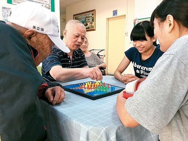 有德養護中心是台南市東區的C級單位,提供長輩活動地點,圖為志工與長輩玩桌遊。 記者鄧桂芬/攝影