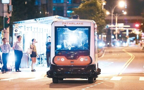 無人駕駛巴士昨凌晨1時至4時在台北市信義路公車專用道進行測試，吸引夜歸民眾拍照。 記者黃威彬／攝影