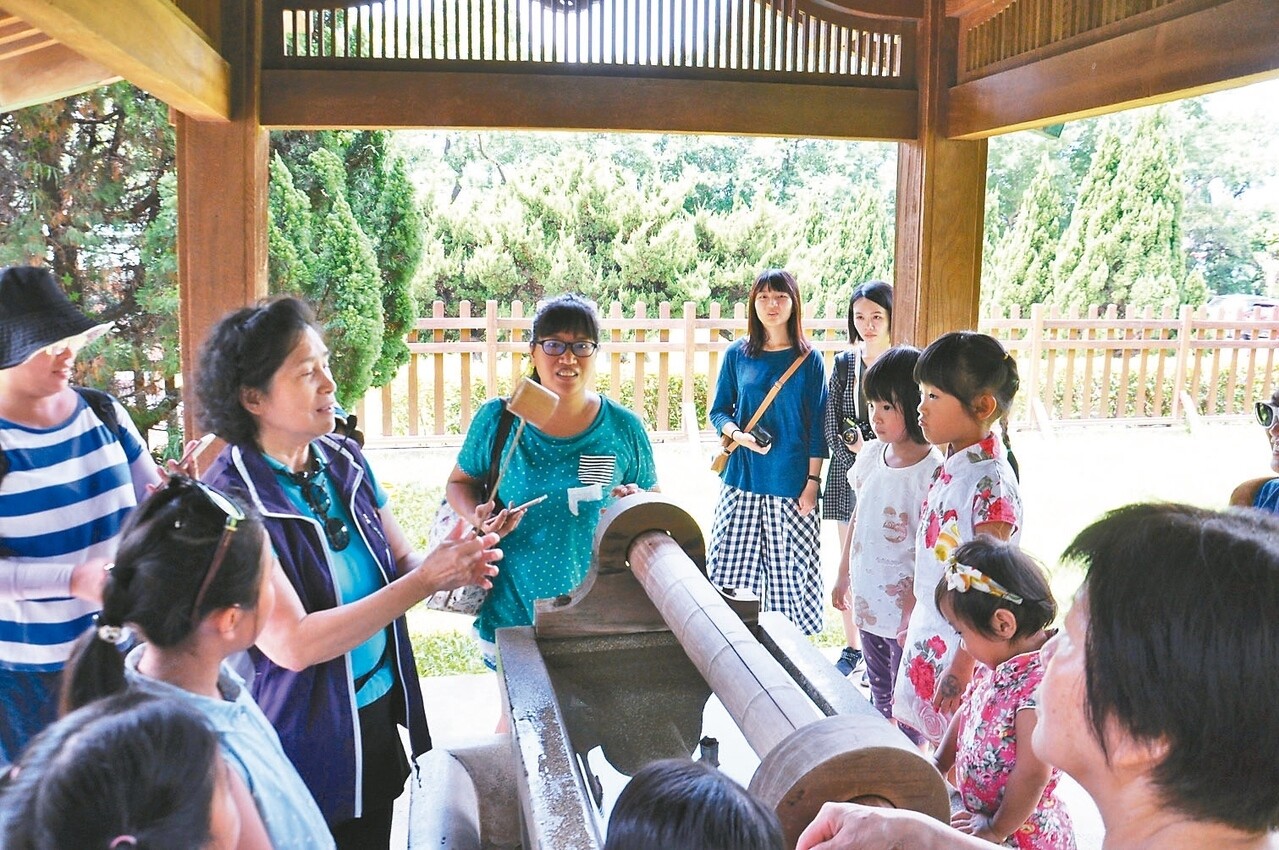 導覽志工領著民眾漫步桃園忠烈祠暨神社文化園區，介紹鳥居、手水舍等設施。 記者張裕珍／攝影