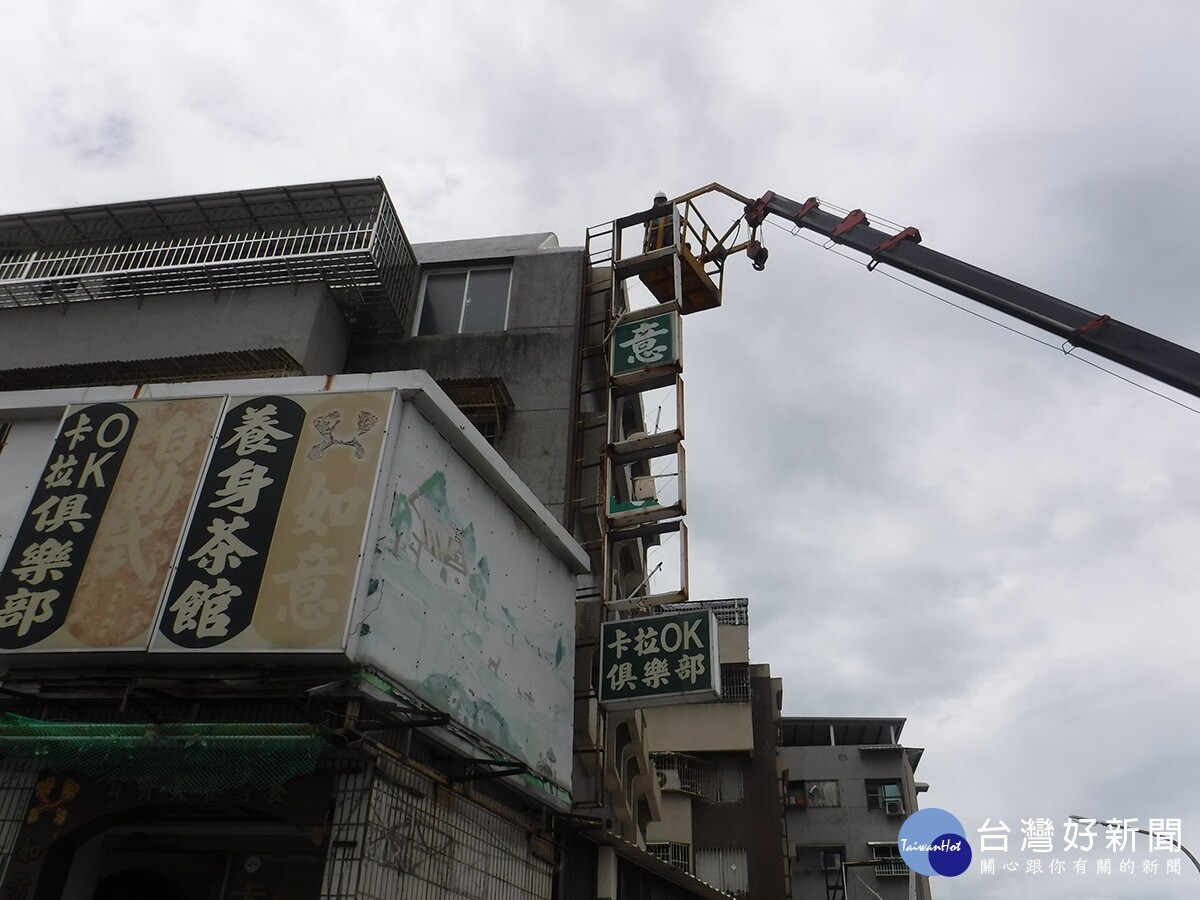 三民區大昌二路與春陽街口12樓高巨幅帆布廣告，救災人員頂著十級強風拆除最是驚險。（台灣好新聞）