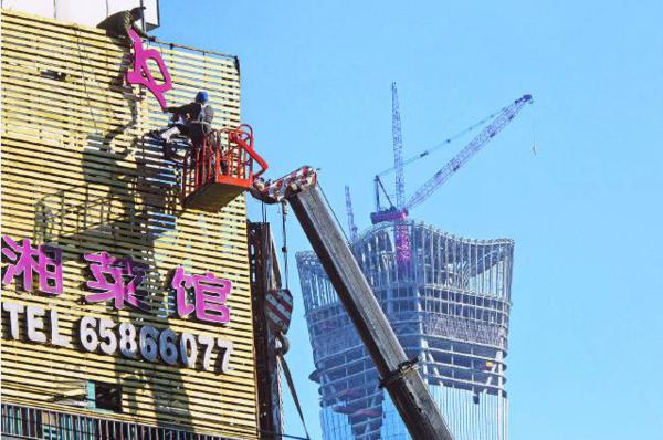 清理拆違規廣告牌 工人拆除廣告招牌。(中國禁聞網)