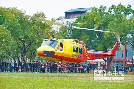 空勤總隊致贈成大航太系一架UH-1H直升機,當飛機直接降落系館草皮上,引起圍觀師生一陣讚嘆。(曹婷婷攝)