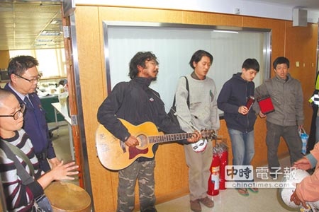 一群「堀仔頭生態藝術村」青年，28日拿著各式樂器，以行動劇控訴市府「假協商、真招標」。（程炳璋攝）