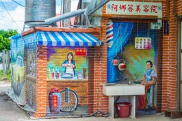 紅磚牆上的彩繪巧妙地點出了早年民眾生活樣態。只是這個美容院跟百歲湯要價也太貴了吧？