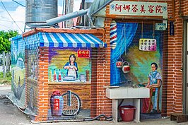 紅磚牆上的彩繪巧妙地點出了早年民眾生活樣態。只是這個美容院跟百歲湯要價也太貴了吧？