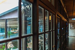 落地的玻璃木格拉門倒映著用餐的人，形成一個好似現實又不現實的景象。