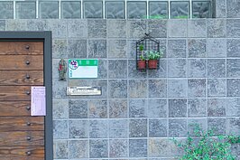 重新拉皮過的老公寓一樓，小小的盆栽掛在厚實簡潔的灰色磚牆上。小小的室外插香的香爐透露出主人虔誠的信仰；保佑一家人平安過日子。