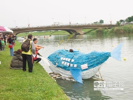 利用數百個保特瓶所打造出的「小鯨號」缺乏方向感，不斷「擱淺」在岸邊動彈不得。（胡健森攝）