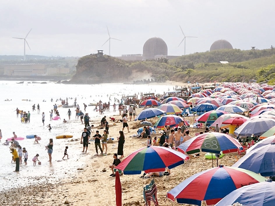 南灣沙灘陽傘五顏六色且凌亂，墾管處計畫在暑假前統一更換。 記者潘欣中／攝影