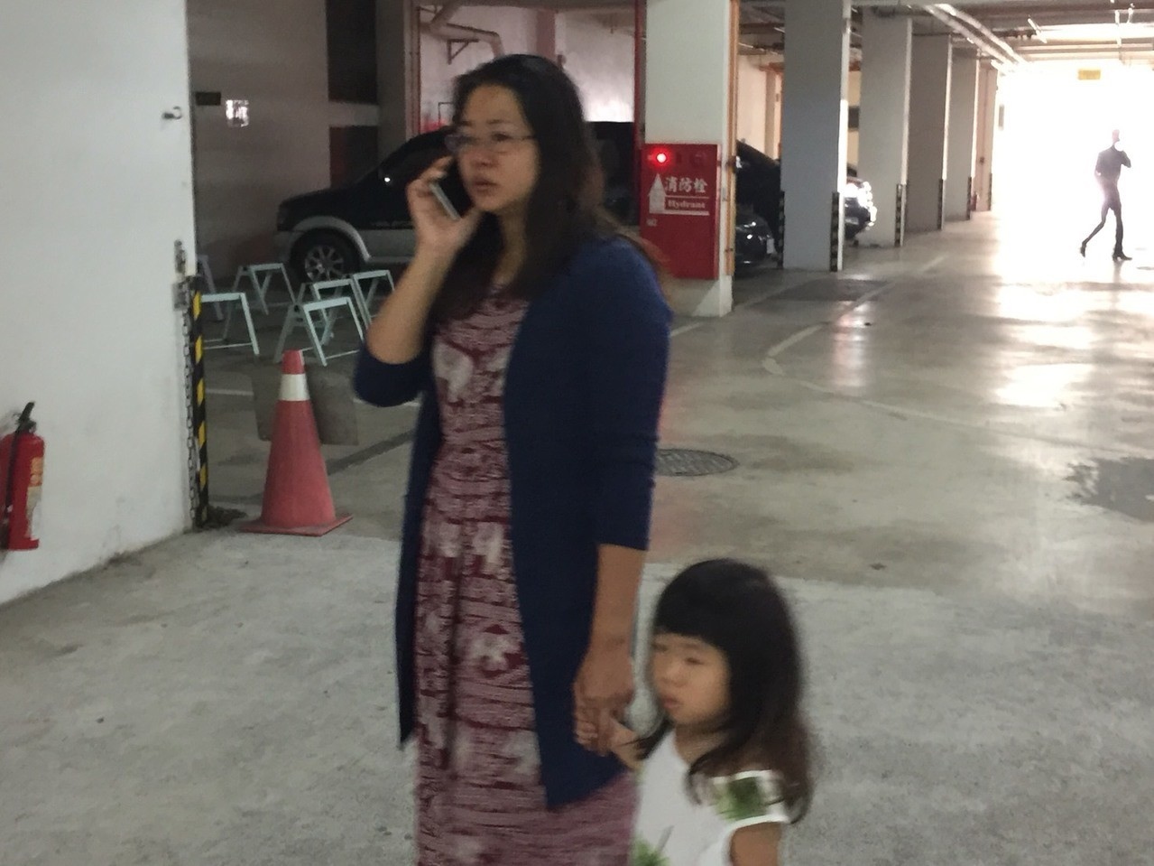 葉家豪的妻子（左）一邊接電話，一邊帶著女兒。 記者吳政修／攝影