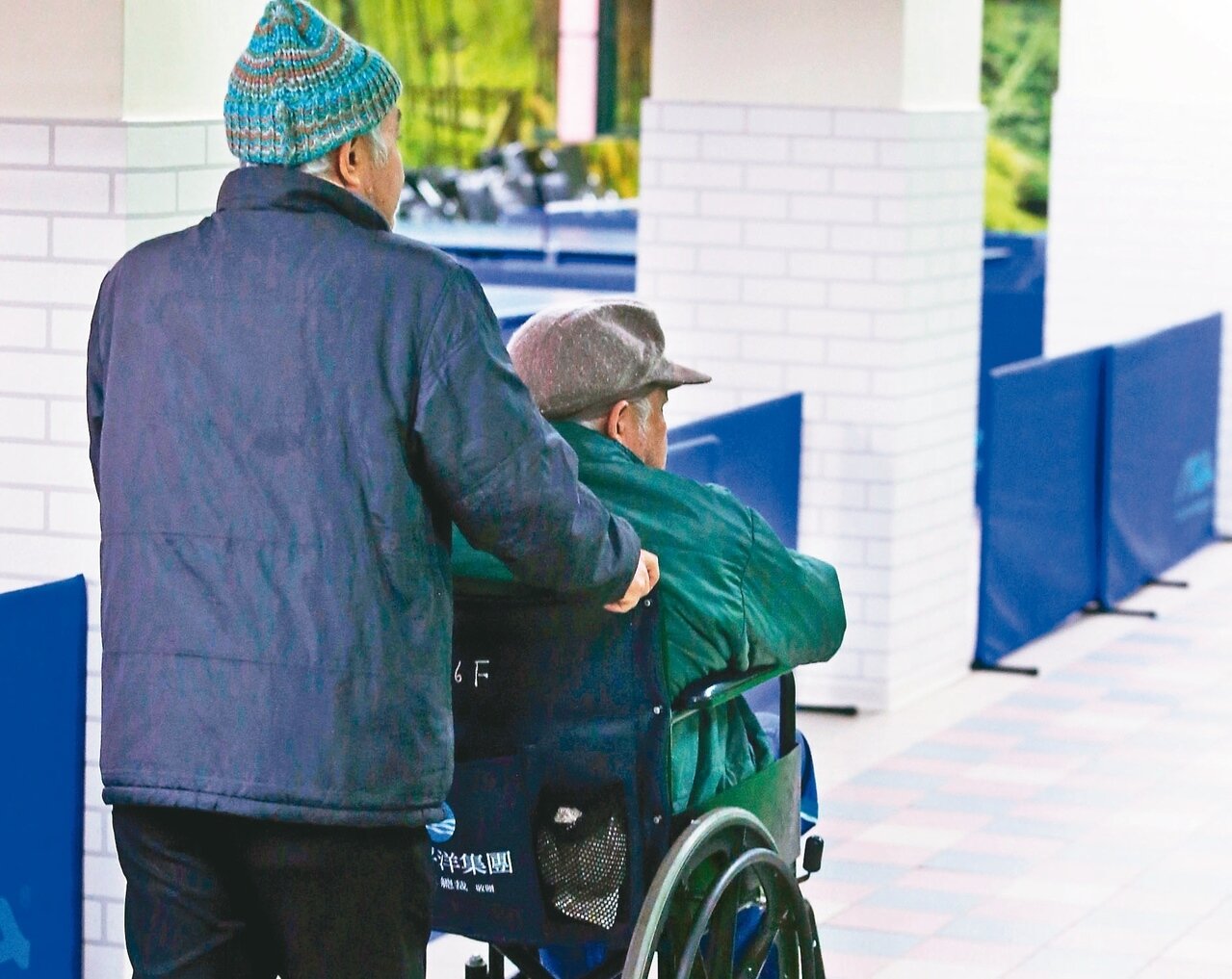台灣愈來愈多人選擇不婚不生,過往老後依賴配偶及子女架起的防護網,未來可能愈來愈多是由手足撐起。圖為一對同住浩然敬老院的兄弟檔,弟弟推著哥哥輪椅在院區裡散步。 記者邱德祥/攝影