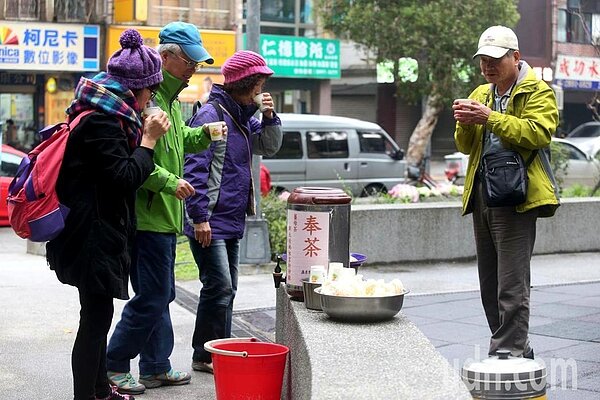 廟宇在公園內奉熱茶和茶點,民眾享用後暖身也暖心。記者邱德祥/攝影