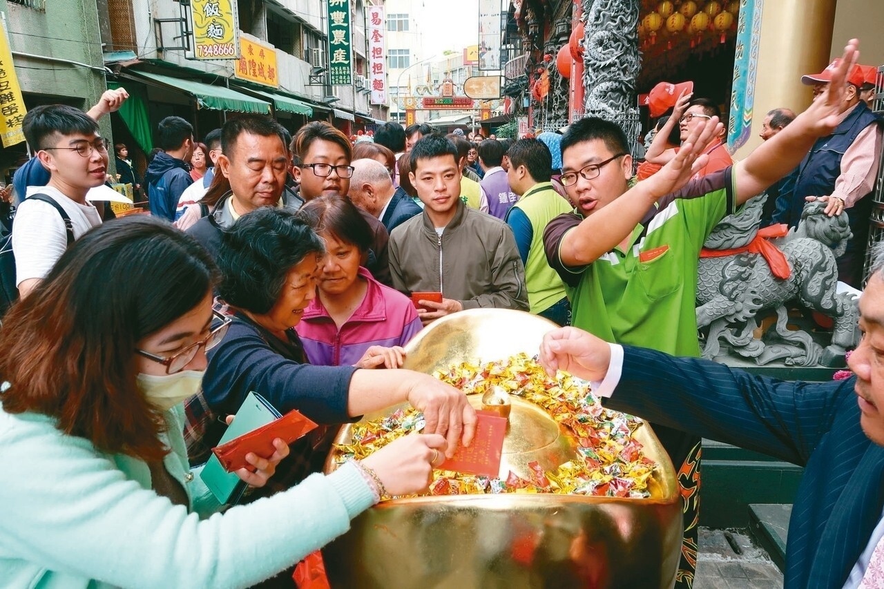 屏東都城煌廟人人搶摸大金元寶。 記者翁禎霞／攝影