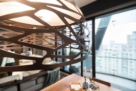餐桌上的吊燈也是鐵件所做成，棕色的鏽感與客廳主風格相呼應。