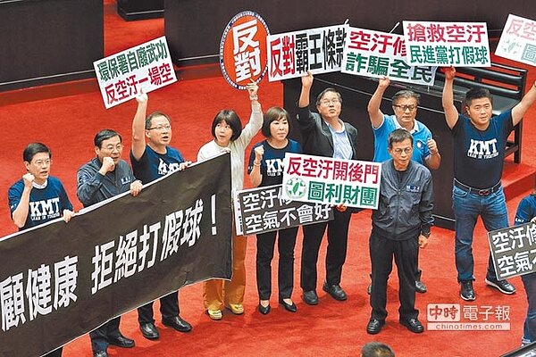 立法院院會25日進行《空氣汙染防制法》修正草案朝野表決攻防大戰,國民黨立委們在表決時高舉標語,批評執政黨向財團靠攏,改善空汙是打假球。(黃世麒攝)