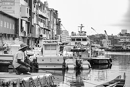 一支釣竿、一頂草帽、一位釣客。正濱漁港的中午十分的寧靜。